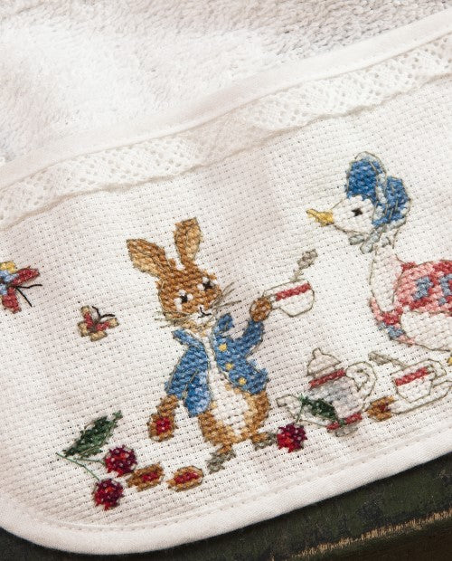 Bavoir en éponge 100 % coton à broder sur Aïda 5,5 points, biais fini à la dentelle. 22 x 33 cm, fabrication française. Grille dans les mooks Pierrot-Lapin n°1 & n°2 et Le roi des éléphants.