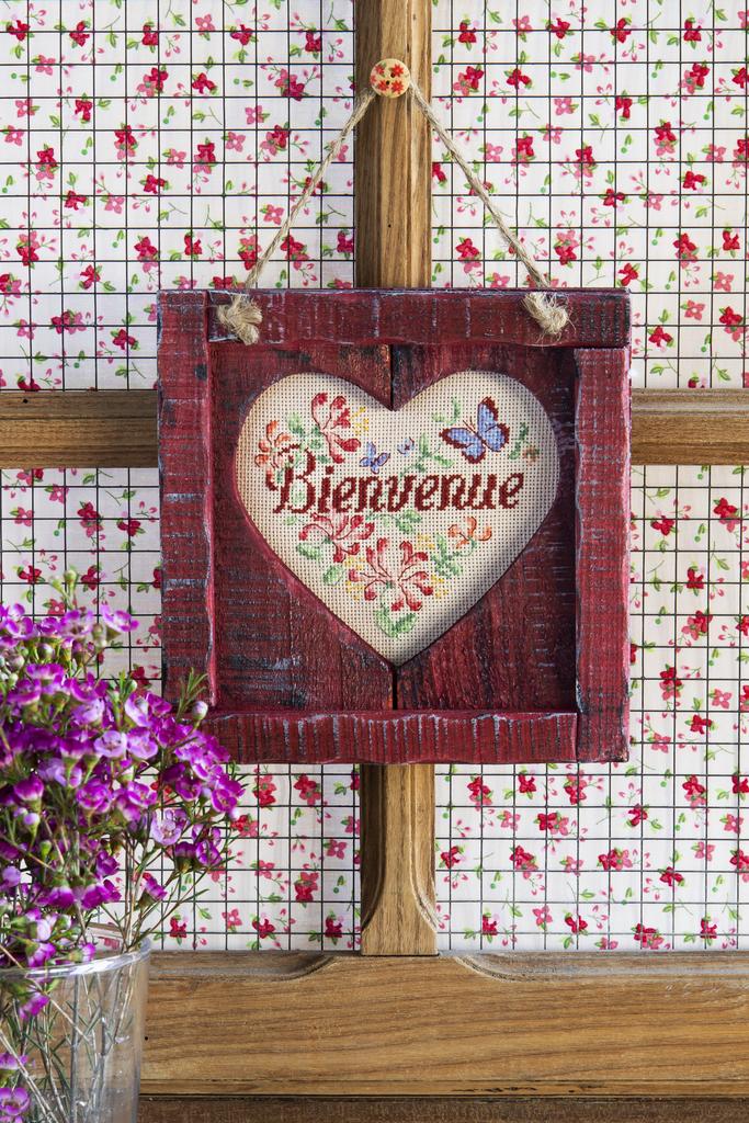 Cadre « Bienvenue » en bois bordeaux (28x28 cm) avec coupon Aïda ivoire, fabrication française. Grille dans Création Point de Croix n°100 (non incluse).