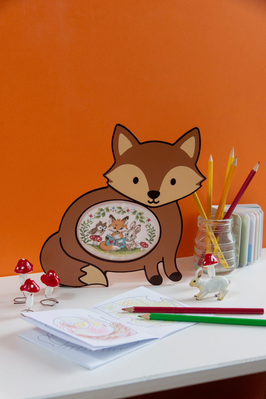 Cadre décoratif en forme de renard, tons orange et beige, ouverture ovale pour broderie d’environ 8 × 11 cm. Style doux et chaleureux, idéal pour chambre d’enfant. Grille disponible dans Création Point de Croix N° 116.