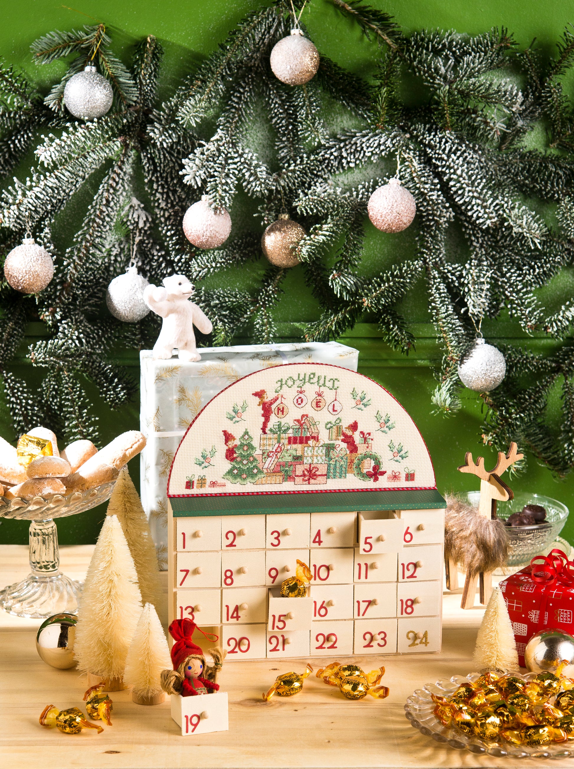 Calendrier de l’Avent en bois brut, 24 tiroirs à suspendre ou poser, idéal pour vos broderies point de croix. Dimensions tiroirs : L 2,6 × H 2,4 × P 4 cm. Grille disponible dans Création Point de Croix N° 115 (non inclus).