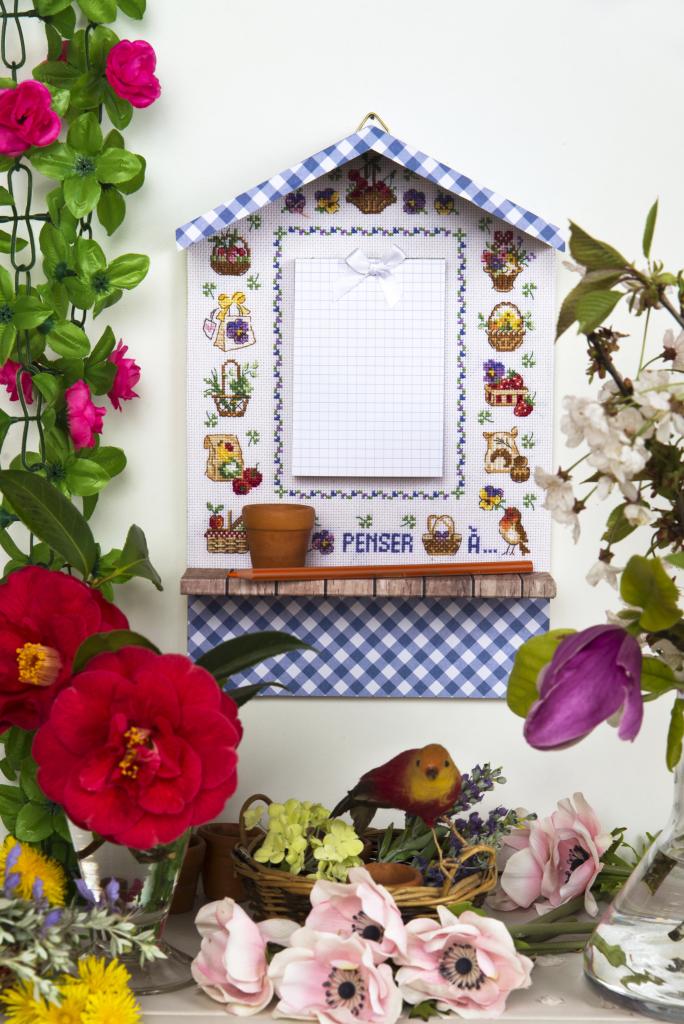 Étagère décorative en forme de maison en pin, à suspendre au mur. Petite tablette intégrée. Dimensions : L 20 × l 6 × H 30,5 cm. Grille disponible dans Création Point de Croix N° 112 (non inclus).