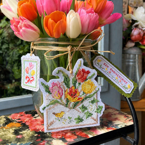 Grille point de croix « Dites-le avec des fleurs ! » : enveloppes brodées tulipes et coquelicots, timbres et étiquettes. À retrouver dans CPC n°119.