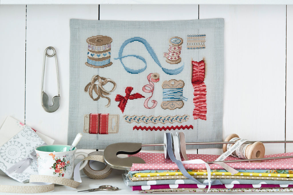 Mook point de croix : 15 créations mêlant petite couture et broderie, avec des motifs originaux autour de la mercerie — dés à coudre, boutons, rubans et ciseaux.