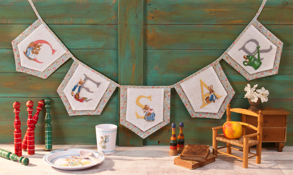 Mook point de croix : +50 motifs Pierrot-Lapin inspirés de Beatrix Potter — scénettes tendres et malicieuses à broder sur bavoir, cadre, cape de bain et accessoires.