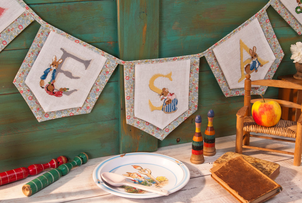 Mook point de croix : +50 motifs Pierrot-Lapin inspirés de Beatrix Potter — scénettes tendres et malicieuses à broder sur bavoir, cadre, cape de bain et accessoires.