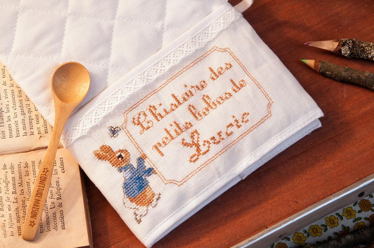 Mook point de croix : +50 motifs Pierrot-Lapin inspirés de Beatrix Potter — scénettes tendres et malicieuses à broder sur bavoir, cadre, cape de bain et accessoires.