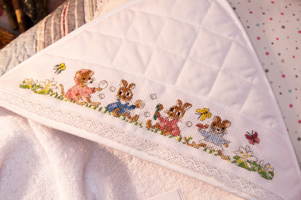 Mook point de croix : +50 motifs Pierrot-Lapin inspirés de Beatrix Potter — scénettes tendres et malicieuses à broder sur bavoir, cadre, cape de bain et accessoires.
