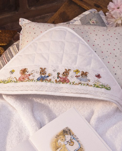 Sortie de bain 78 x 78 cm en éponge 100 % coton avec capuche matellassée, à broder sur Aïda 5,5 points, biais à la dentelle. Fabrication française. Grille dans les mooks Pierrot-Lapin n°1 & n°2 et Le roi des éléphants n°1.