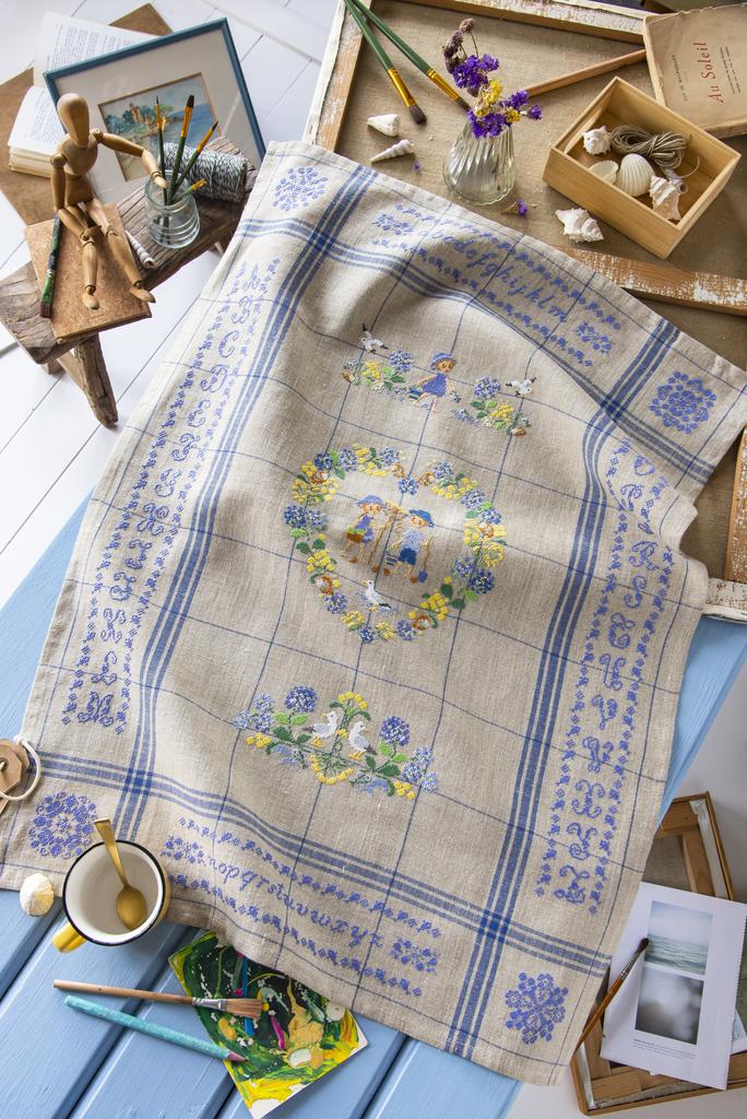 Torchon Été Mer 100 % lin 58x80 cm, liteaux bleus, bride d’accrochage. Fabriqué en France. Grille dans CPC n°107.